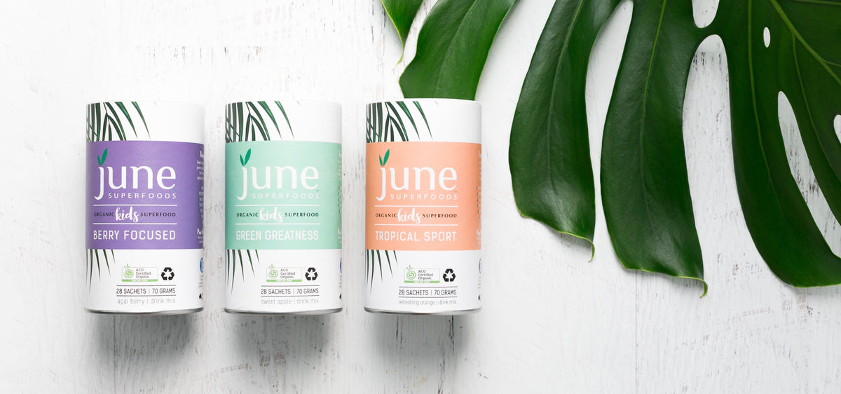 Three canisters of June Superfoods with a monstera leaf